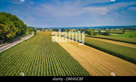 Drone vue de la campagne amish avec des granges et des silos et une voie ferrée unique voyageant à travers elle Banque D'Images