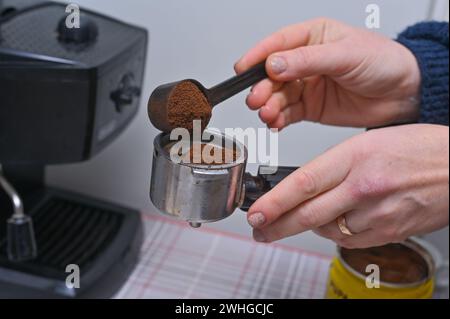 les mains des femmes versent le café dans le porte-filtre de la machine à café. gros plan Banque D'Images