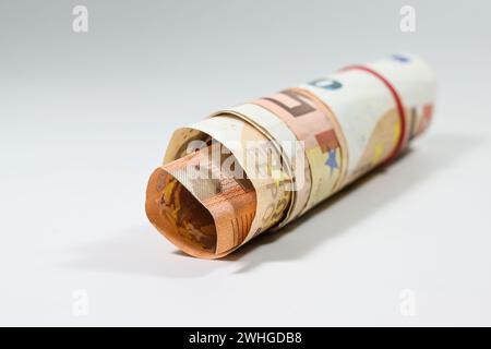 Quelques billets de 50 euros enroulés en un petit rouleau sur un fond clair avec espace de copie, focus sélectionné Banque D'Images