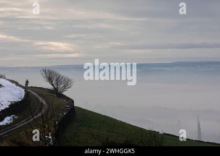 West Yorkshire, UK.10th Feb, 2024. UK Weather.Northowram, West Yorkshire, Royaume-Uni. La brume tôt le matin pend autour des maisons et des pylônes dans les vallées autour de Halifax, West Yorkshire créant une atmosphère magique au paysage Pennine. Crédit : Windmill images/Alamy Live News Banque D'Images