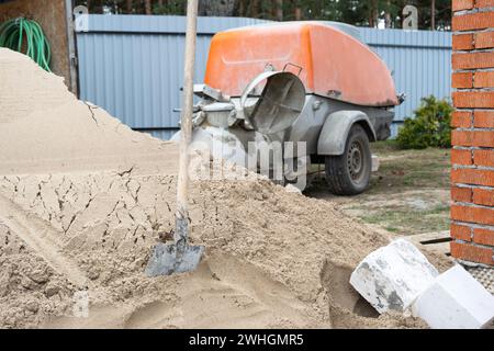 Une machine avec un mélangeur est une installation pour alimenter le mélange de ciment pour verser la chape de sol semi-sèche dans la maison. Constructio Banque D'Images