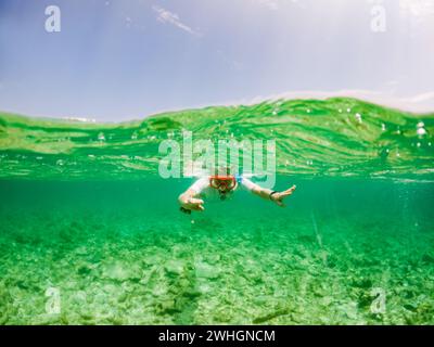 Femme snorkeling dans la mer tropicale claire Banque D'Images