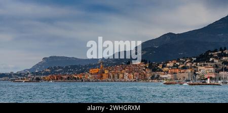 Vue panoramique sur le vieux centre-ville coloré de Menton avec la mer Méditerranée bleue au premier plan Banque D'Images