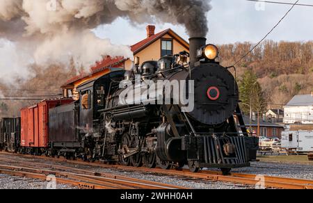 Vue d'un train de fret à vapeur antique restauré approchant tôt le matin, sur d'anciennes voies à voie étroite Banque D'Images