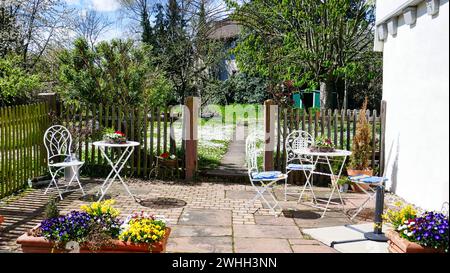 Belle terrasse de jardin avec tables et chaises au printemps Banque D'Images