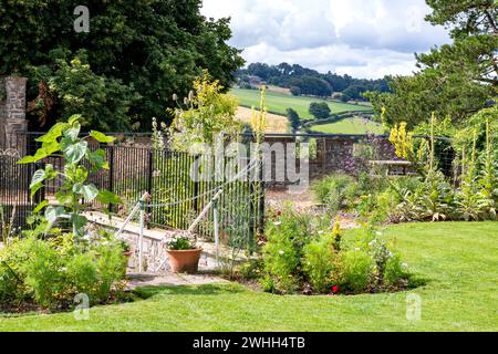 Scène de jardin tranquille dans les jardins communautaires de Great Torrington Castle avec mur de limite, balustrades, marches et arbres sur Castle Hill, avec vue rurale. Banque D'Images