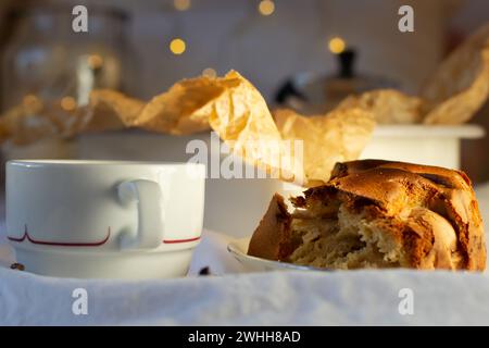 Un morceau de tarte aux pommes fraîchement cuit et une tasse blanche de café sur une base de coton blanc Banque D'Images