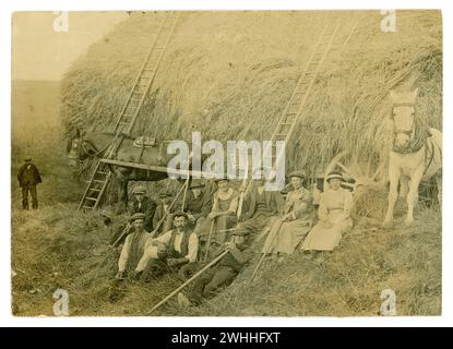 Carte postale originale de l'ère WW1 de la scène de récolte avec des ouvriers agricoles, on est une fille de l'armée de terre - portant un brassard de service de 3 mois. Écrit au verso est Preston court Farm emplacement inconnu. Daté de 1916 Banque D'Images