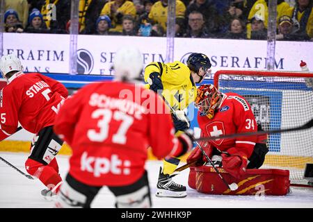 KARLSTAD, SUÈDE 20240210Le suédois Joakim Nygard (#11) marque le premier but contre le gardien suisse Stéphane Charlin lors des Jeux de hockey de Beijer (UE Banque D'Images