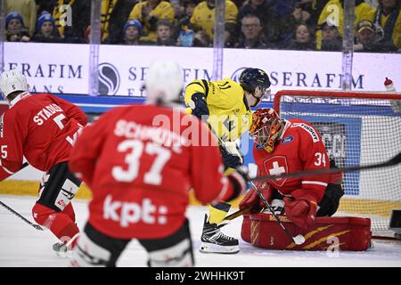 KARLSTAD, SUÈDE 20240210Le suédois Joakim Nygard (#11) marque le premier but contre le gardien suisse Stéphane Charlin lors des Jeux de hockey de Beijer (UE Banque D'Images