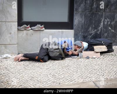 Homme sans-abri dormant dans la rue à Lisbonne et demandant de l'argent pour survivre Banque D'Images