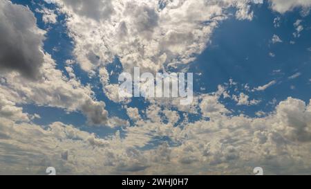 Vue expansive d'Un ciel bleu rempli de nuages de Cumulus blancs projetant des ombres les unes sur les autres sous la lumière du soleil. Banque D'Images