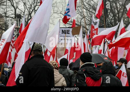 Varsovie, Pologne, 10 février 2024. Une foule de personnes, portant des drapeaux nationaux polonais et des banderoles antigouvernementales, dirigée par les médias d'extrême droite - Gazeta Polska et TV Republica et droit et justice (Prawo i Sprawiedliwość - PIS) les dirigeants des partis politiques organisent une manifestation de soutien aux juges actuels de la Cour constitutionnelle devant le bâtiment de la Cour sur la rue Szucha. La Pologne traverse une crise constitutionnelle alors que le gouvernement centriste actuel affirme que les juges de la Cour constitutionnelle ont été illégalement installés par un ancien gouvernement de droite. L'opposition de droite démontre le soutien des juges de la Cour Banque D'Images