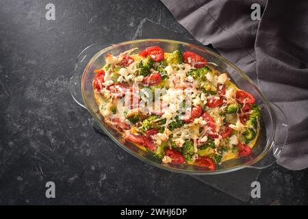 Casserole de brocoli, tomates, oignons, feta et fromage, plat de légumes sains sur un fond d'ardoise gris foncé, angle élevé v Banque D'Images