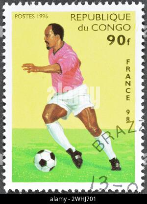 Timbre-poste annulé imprimé par Congo, qui montre joueur de football, en promotion de la coupe du monde de la FIFA en France 98, vers 1996. Banque D'Images