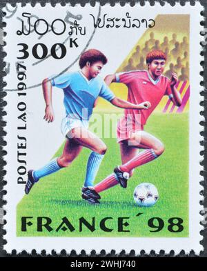 Timbre-poste oblitéré imprimé par le Laos, qui promeut le football, Coupe du monde de la FIFA, France -1998, circa 1997. Banque D'Images