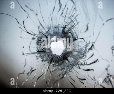 Trou de balle dans la vitre fissurée Banque D'Images