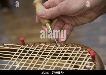 L'invention concerne un appareil de fabrication de paniers qui tisse un panier Banque D'Images