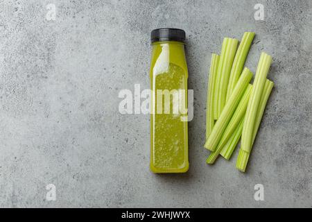 Bouteille de smoothie de céleri vert avec des bâtons de céleri frais sur fond de béton gris vue de dessus. Boisson diététique, nutrition saine, Banque D'Images