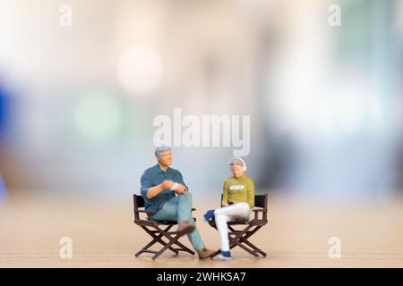 Jeune couple assis sur une chaise écoutant de la musique et buvant du café, concept de la Saint-Valentin Banque D'Images