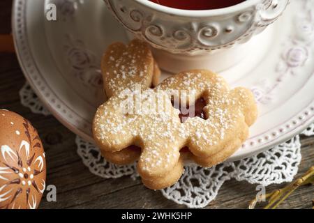 Biscuit Linzer en forme de lapin de Pâques et une tasse de thé Banque D'Images