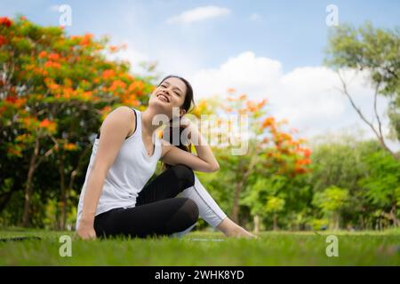 Jeune femme avec des activités de plein air dans le parc de la ville, le yoga est son activité choisie. Banque D'Images