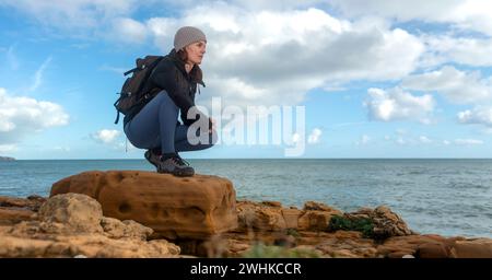 Femme sportive randonneur sur les rochers au bord de la mer Banque D'Images