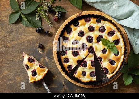 Tarte aux mûres maison. Pâtisserie végétalienne sans gluten, desserts végétaliens. Tarte sucrée avec mûre et crème anglaise sur table en bois. Vue f Banque D'Images