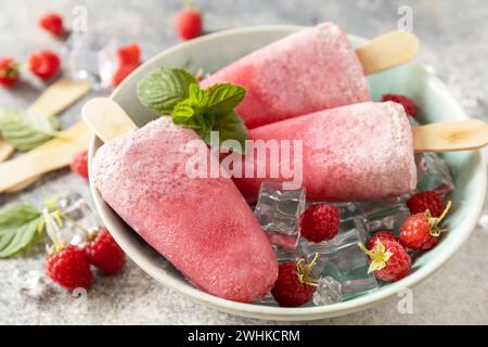 Crème glacée. Dessert d'été. Popsicles à la framboise maison avec yaourt et framboises sur un fond de pierre grise. Banque D'Images