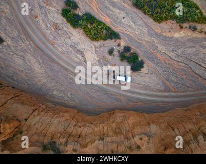 Véhicule hors route sur une piste dans un lit de rivière, paysage de collines érodées, top-down, badlands, vue aérienne, Canyon des rivières oubliées, Issyk Kul Banque D'Images