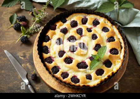 Tarte sucrée avec mûre et crème anglaise sur table en bois. Tarte aux mûres maison. Pâtisserie végétalienne sans gluten, desserts végétaliens. Banque D'Images