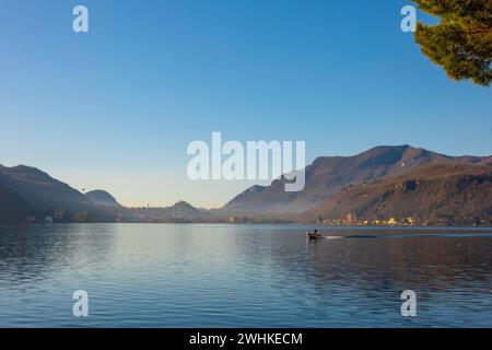 Voyage en bateau sur le lac de Lugano avec montagne et ville dans une journée ensoleillée avec ciel clair à Porto Ceresio, Lombardie, Italie Banque D'Images