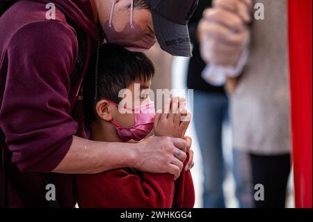 Hong Kong, Chine. 10 février 2024. Un père et son fils commencent l'année du Dragon en offrant des prières au temple Wong Tai Sin. Le temple Sik Sik Yuen Wong Tai Sin est l'un des plus grands temples taoïstes de Hong Kong et beaucoup de gens viennent ici pour offrir les premiers bâtons de joss de la nouvelle année avec des prières pour le bonheur et la santé. (Photo de Ben Marans/SOPA images/SIPA USA) crédit : SIPA USA/Alamy Live News Banque D'Images