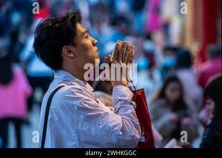 Hong Kong, Chine. 10 février 2024. Un adorateur commence l'année du Dragon en offrant des prières au temple Wong Tai Sin. Le temple Sik Sik Yuen Wong Tai Sin est l'un des plus grands temples taoïstes de Hong Kong et beaucoup de gens viennent ici pour offrir les premiers bâtons de joss de la nouvelle année avec des prières pour le bonheur et la santé. (Photo de Ben Marans/SOPA images/SIPA USA) crédit : SIPA USA/Alamy Live News Banque D'Images