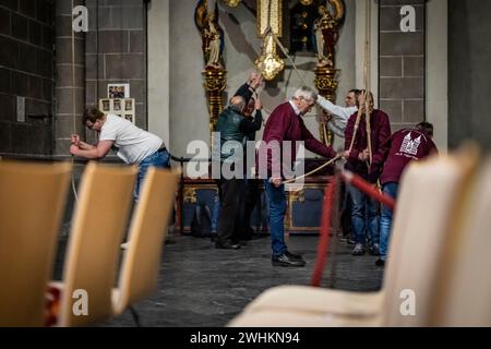 Xanten, Allemagne. 10 février 2024. Les membres de la compagnie de sonnerie tirent sur trois cordes samedi soir pour sonner les trois grosses cloches de la cathédrale. La « compagnie de sonnerie » de la cathédrale de Xanten sonne dimanche à la main 13 hommes, pour la plupart des retraités, sonnent à la main les trois grosses cloches de la cathédrale sur des cordes de 40 mètres de long. Ils suivent une chorégraphie fixe - parfois ils en pendent trois à une corde. Crédit : Christoph Reichwein/dpa/Alamy Live News Banque D'Images