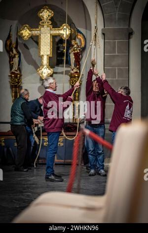 Xanten, Allemagne. 10 février 2024. Les membres de la compagnie de sonnerie tirent sur trois cordes samedi soir pour sonner les trois grosses cloches de la cathédrale. La « compagnie de sonnerie » de la cathédrale de Xanten sonne dimanche à la main 13 hommes, pour la plupart des retraités, sonnent à la main les trois grosses cloches de la cathédrale sur des cordes de 40 mètres de long. Ils suivent une chorégraphie fixe - parfois ils en pendent trois à une corde. Crédit : Christoph Reichwein/dpa/Alamy Live News Banque D'Images