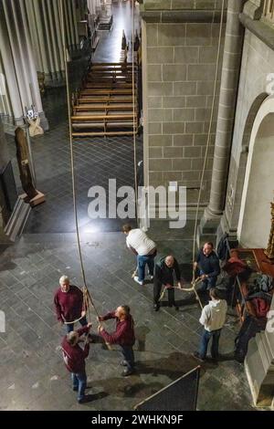 Xanten, Allemagne. 10 février 2024. Les membres de la compagnie de sonnerie tirent sur trois cordes samedi soir pour sonner les trois grosses cloches de la cathédrale. La « compagnie de sonnerie » de la cathédrale de Xanten sonne dimanche à la main 13 hommes, pour la plupart des retraités, sonnent à la main les trois grosses cloches de la cathédrale sur des cordes de 40 mètres de long. Ils suivent une chorégraphie fixe - parfois ils en pendent trois à une corde. Crédit : Christoph Reichwein/dpa/Alamy Live News Banque D'Images