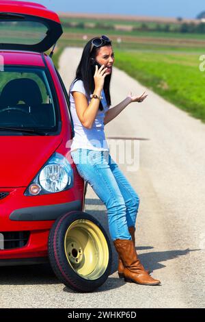 Jeune femme a une panne dans sa voiture, des dommages au moteur, appels ADAC, garage, service Banque D'Images