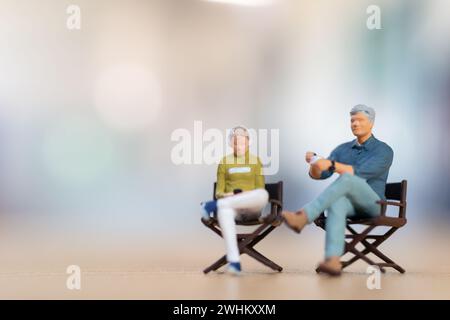 Jeune couple assis sur une chaise écoutant de la musique et buvant du café, concept de la Saint-Valentin Banque D'Images