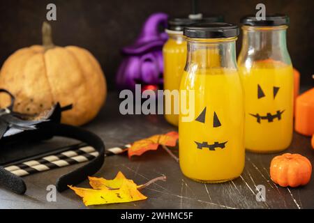 Boisson de citrouille sur une table d'halloween festive et citrouilles d'Halloween, lanterne et décoration sur fond de pierre sombre. Banque D'Images