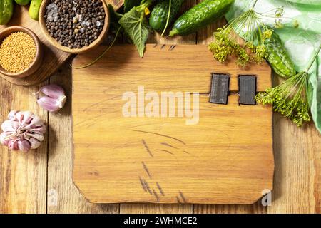 Légumes en conserve. Maquette. Fond en bois avec des concombres préparés pour le marinage et des ingrédients pour la marinade. Récolte pré Banque D'Images