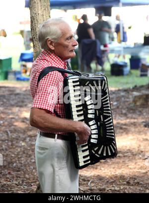 Les musiciens s'affrontent en groupes fluides sous les arbres au pique-nique Old Fiddlers Banque D'Images