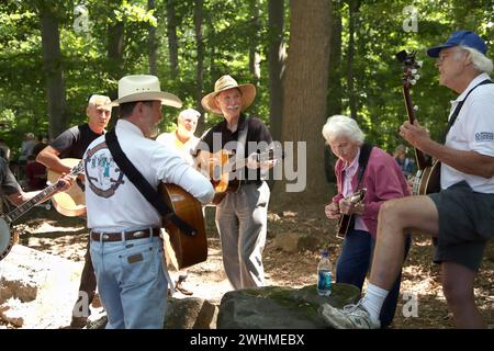 Les musiciens s'affrontent en groupes fluides sous les arbres au pique-nique Old Fiddlers Banque D'Images