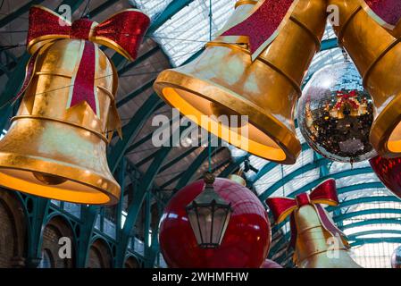 Cloches d'or et boules rouges ornent le décor de Noël au marché de Londres Banque D'Images