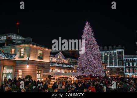 Sapin de Noël lumineux avec une foule joyeuse la nuit à Londres, Royaume-Uni Banque D'Images