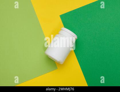 Pot en plastique blanc pour les pilules, la crème et les médicaments sur fond vert. Conteneur pour substances, vue de dessus Banque D'Images