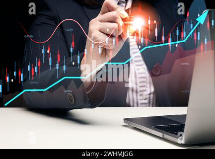 Femme assis à un ordinateur portable devant un graphique holographique avec des indicateurs de croissance. Développement commercial, performances financières élevées Banque D'Images
