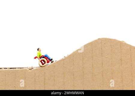 Homme miniature en fauteuil roulant Banque D'Images