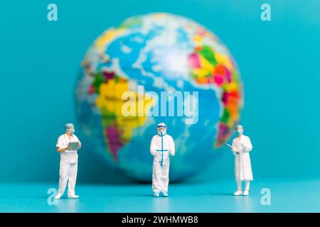 Le médecin et l'infirmière en miniature vérifiant les soins de santé mondiaux Banque D'Images