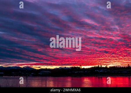 Ciel d'hiver rouge profond au-dessus de l'estuaire de l'île de Vancouver, reflet rouge dans l'eau. Banque D'Images